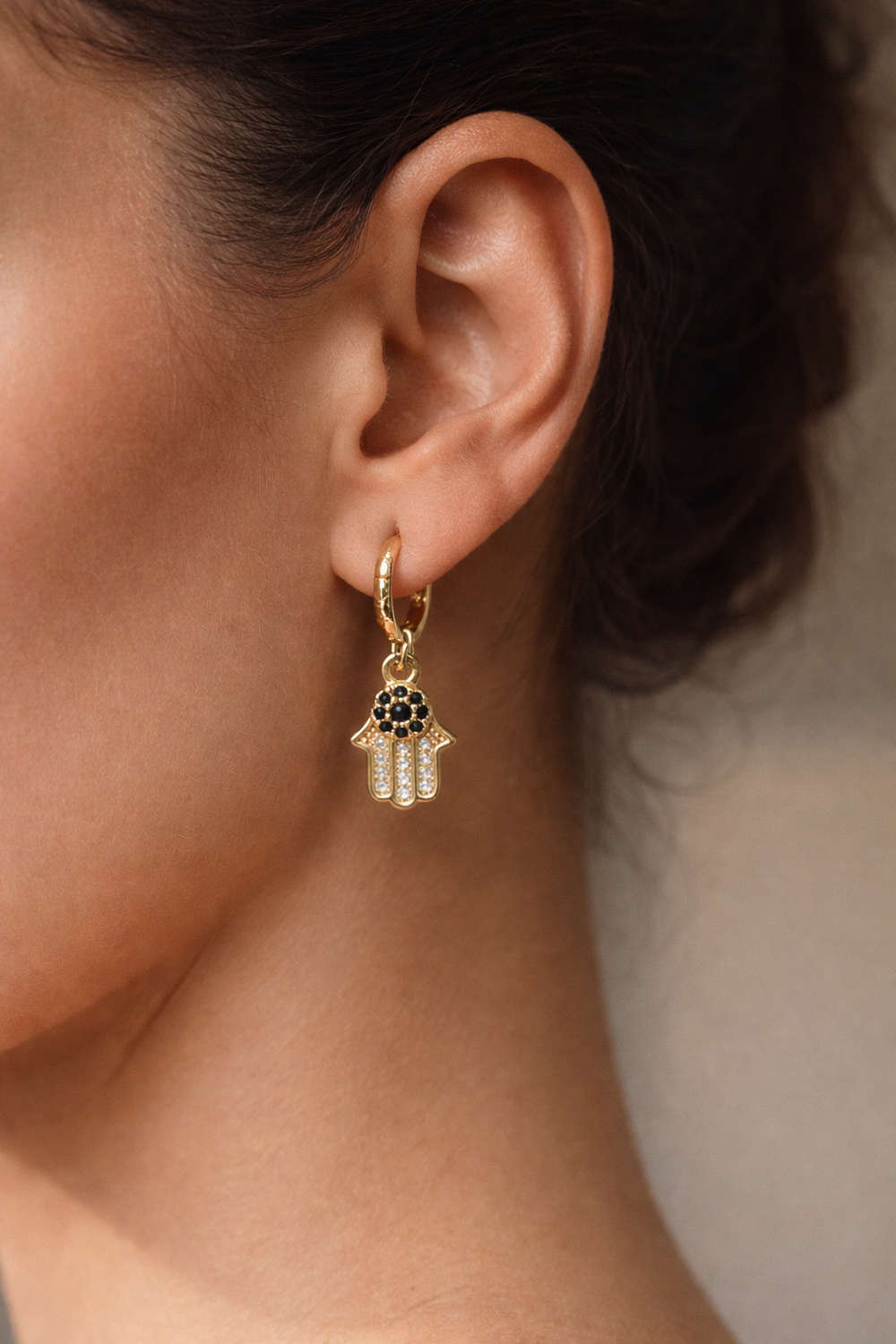 Noora Hamsa Earrings detail showing Hamsa hand charm and gold hoop close-up